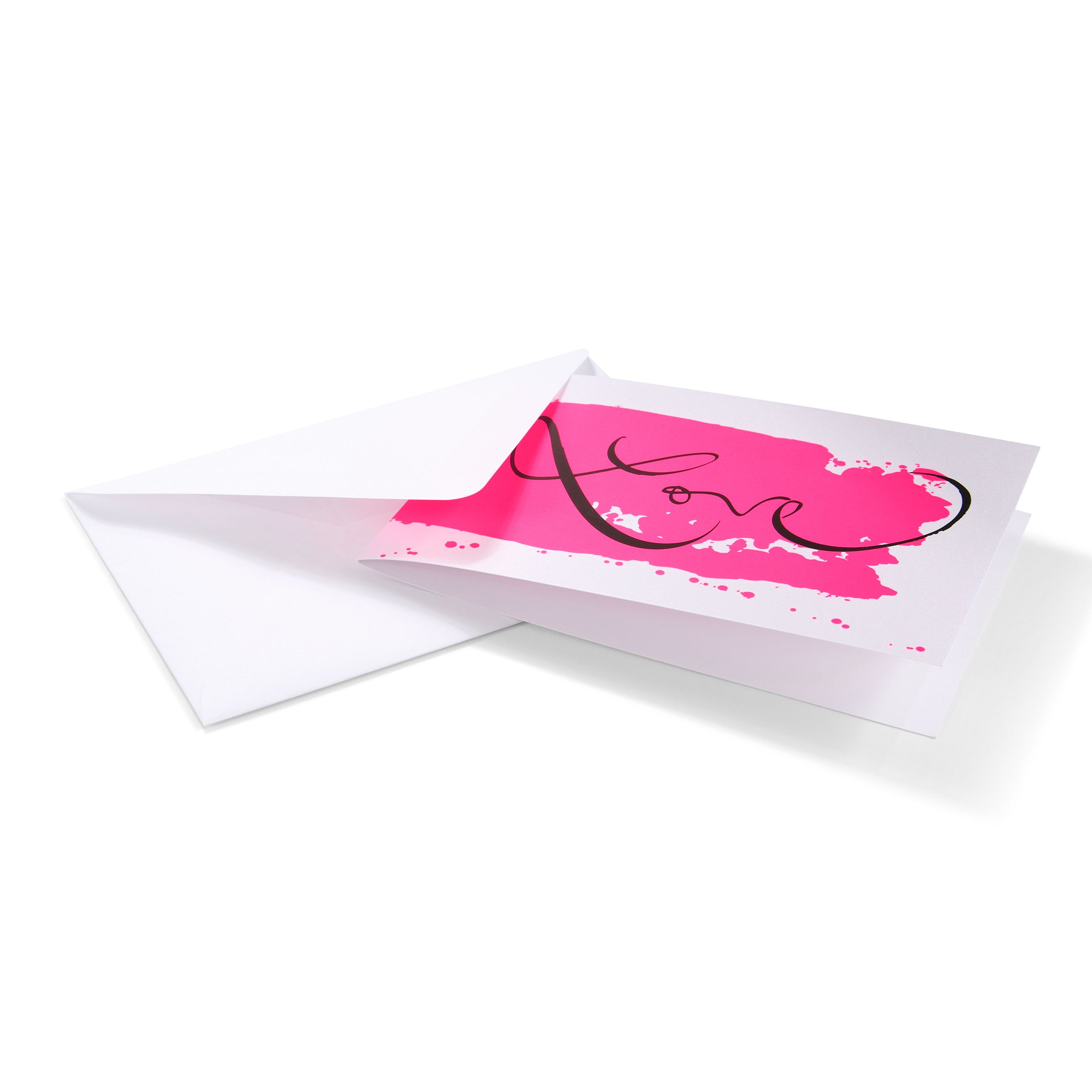 A white greeting card partially pulled from a matching white envelope, displaying a bold pink paint-like stroke with elegant black “Love” lettering across the front.