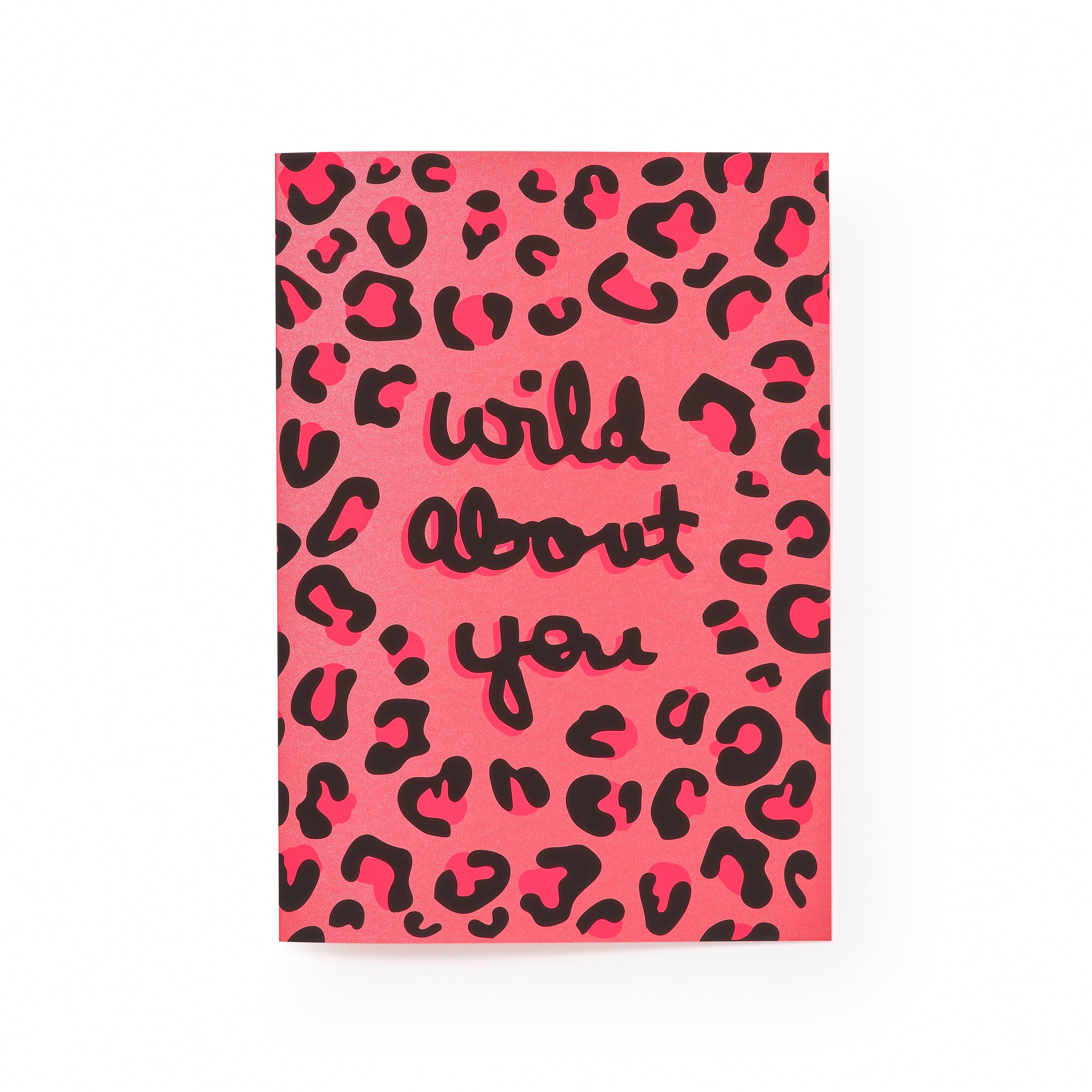 Greeting card displayed upright with a bright pink leopard-print pattern and bold black handwritten-style text reading “wild about you,” centered on the card front.