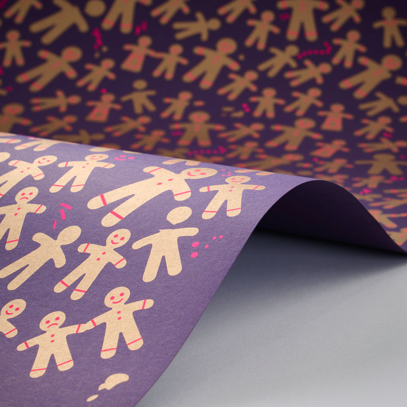 Wrapping paper sheet featuring a playful pattern of golden gingerbread figures on a deep purple background, shown curled to reveal the repeating design with bright pink accents.