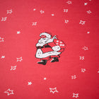 Wrapping paper with a festive pattern of a vintage-style Santa carrying a star-covered sack, surrounded by scattered white hand-drawn stars on a bright red background.