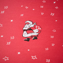 Wrapping paper with a festive pattern of a vintage-style Santa carrying a star-covered sack, surrounded by scattered white hand-drawn stars on a bright red background.