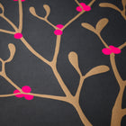 Wrapping paper with a festive pattern of golden mistletoe branches scattered across a deep charcoal background, accented by bright pink berries.