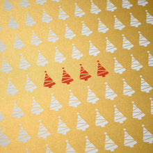 Wrapping paper with a festive pattern of tiny white Christmas trees scattered across a shimmering gold background, accented by a small row of bright red trees.