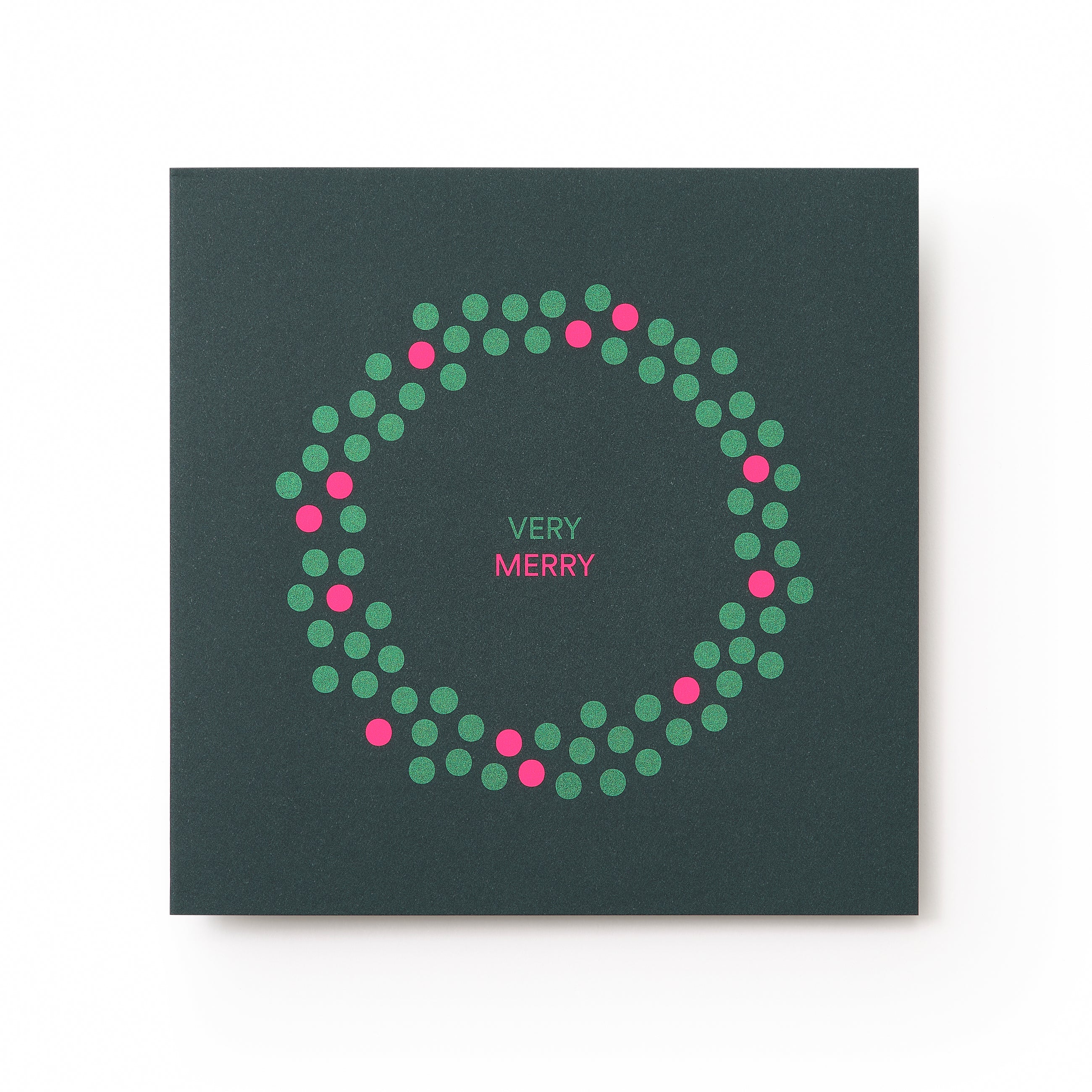 A dark green Christmas card with a minimalist wreath design made of green and pink dots, surrounding the text "VERY MERRY" in pink and white at the center.