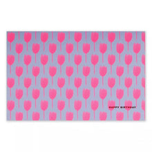 A rectangular greeting card with a lilac background, covered in a repeating pattern of bright pink tulip silhouettes, with “HAPPY BIRTHDAY” printed in small text in the corner.
