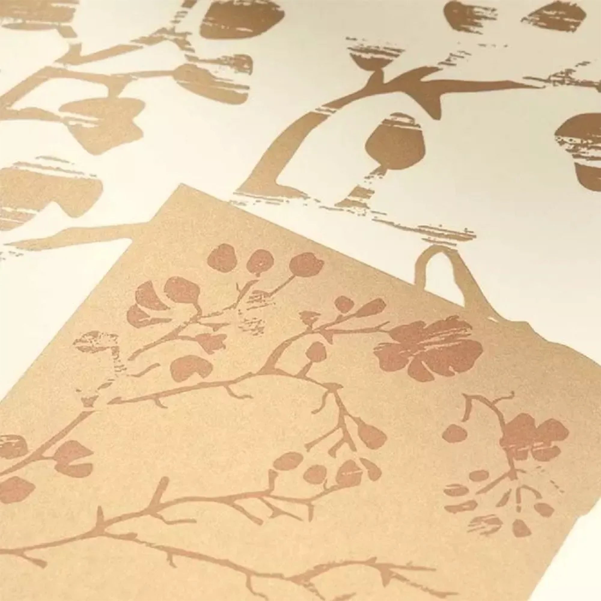 A close-up view of shimmering gold foliage and branch patterns, revealing textured, painterly details with a subtle metallic sheen on a warm cream surface.