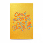 A vibrant greeting card with a warm golden-yellow background, featuring playful script lettering in bright orange with a soft blue shadow reading “Cool parents, cool baby,” alongside a small pacifier icon.