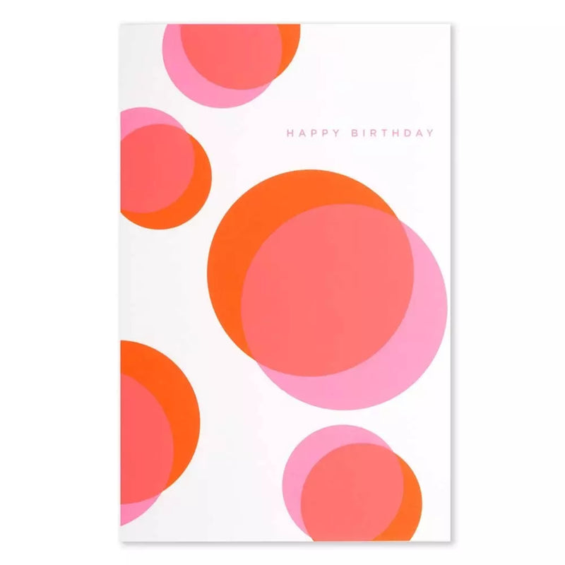 A white greeting card with overlapping circular shapes in bright orange and soft pink, featuring the words “HAPPY BIRTHDAY” in small, subtle lettering.