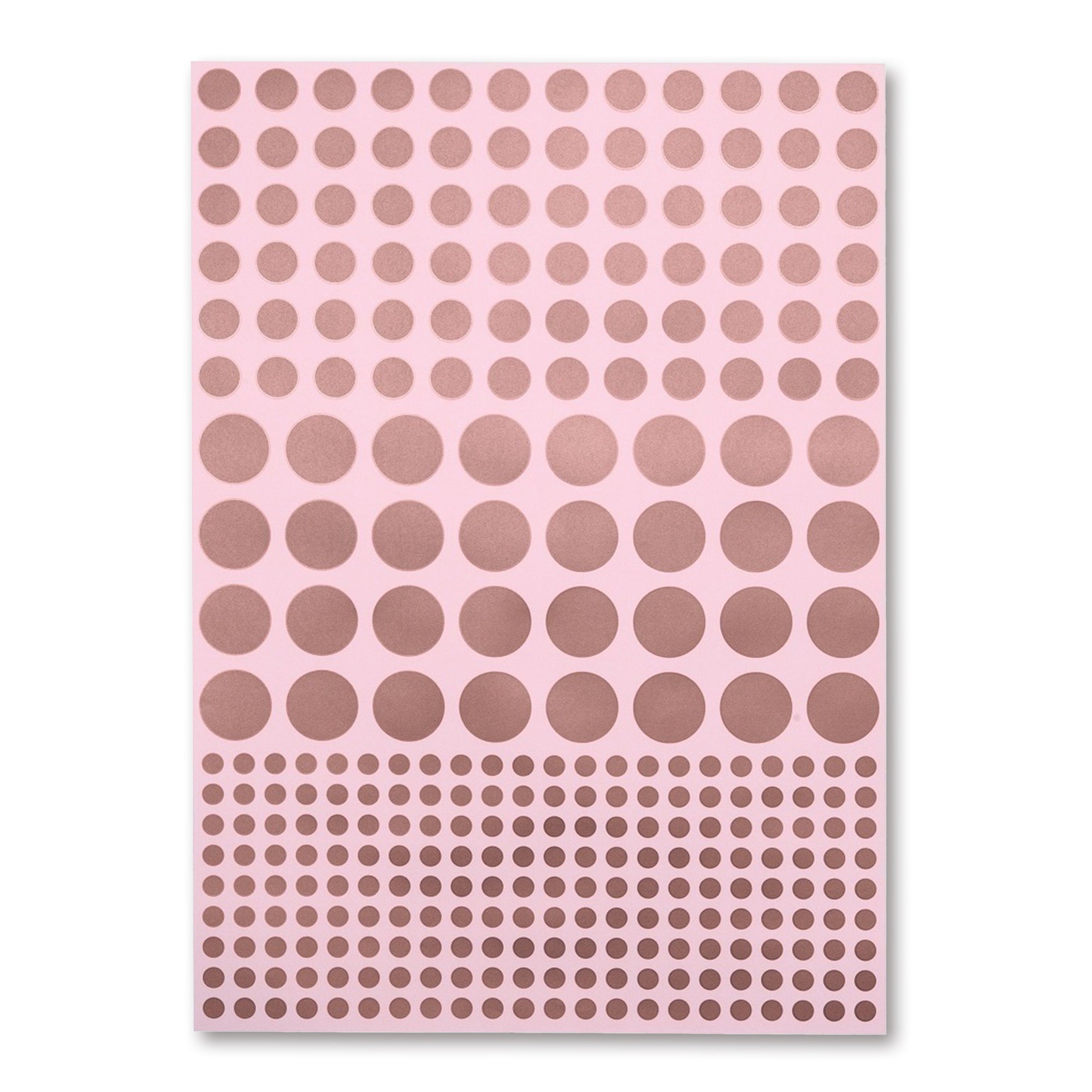 A soft pink sheet of wrapping paper covered in neat rows of metallic copper dots, arranged from medium to large to small for a subtle gradient effect.