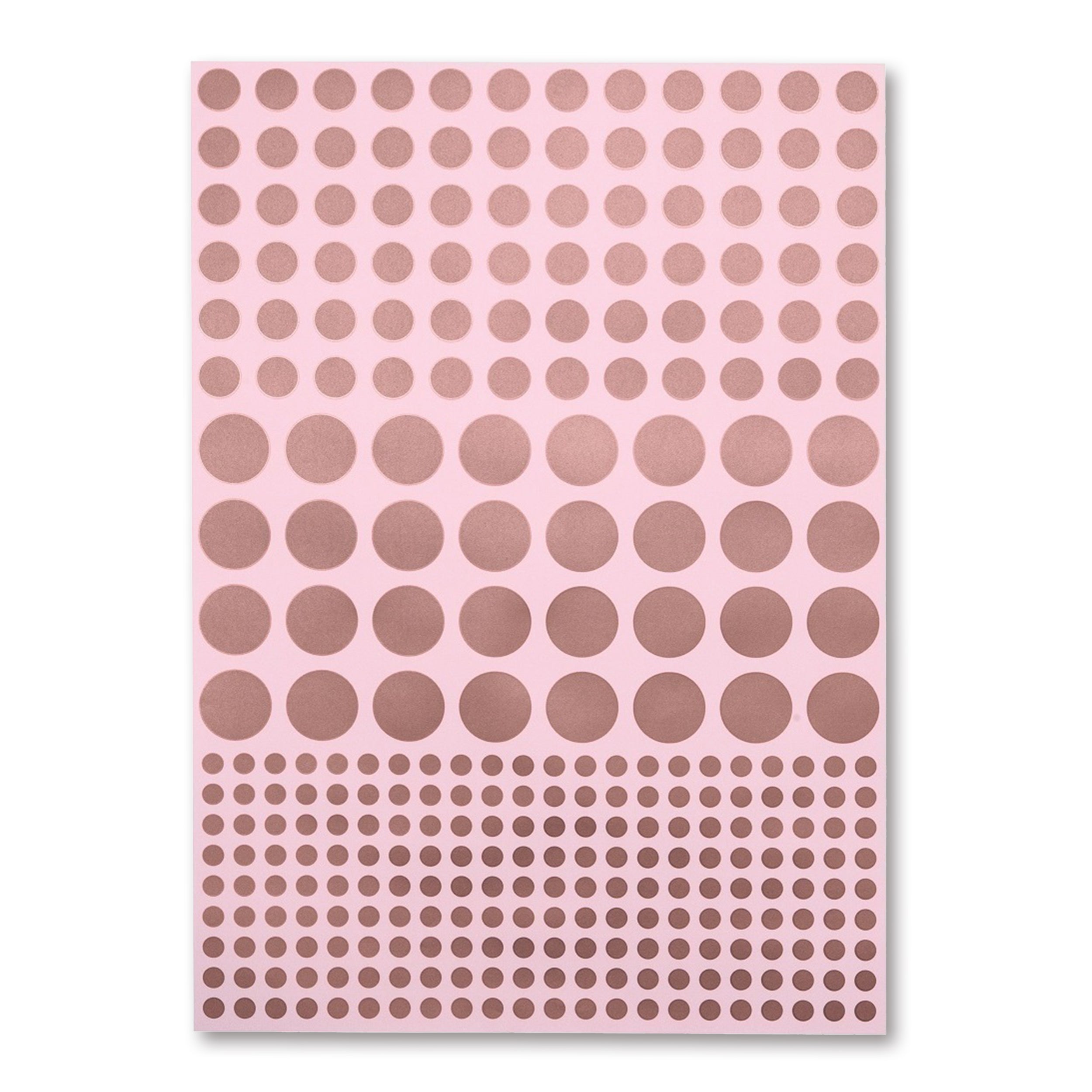 A soft pink sheet of wrapping paper covered in neat rows of metallic copper dots, arranged from medium to large to small for a subtle gradient effect.