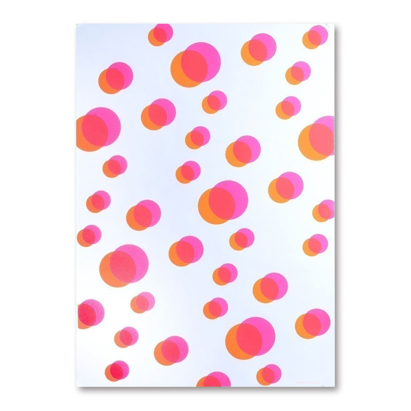 Wrapping paper featuring overlapping circular shapes in pink and orange tones, scattered across a white background to create a light, floating pattern.