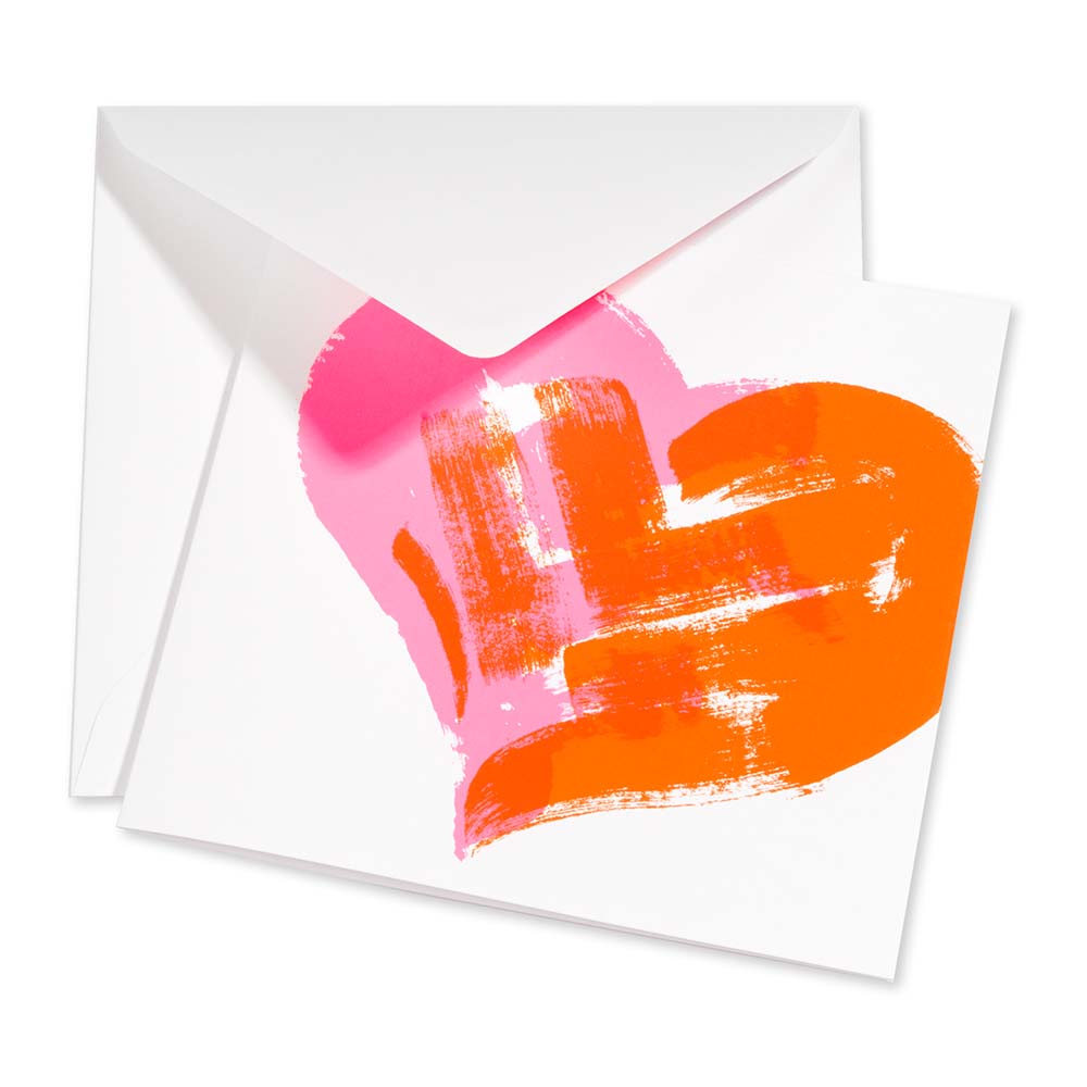 Greeting card with a bold neon pink and orange painted heart on a white background, shown partially open with a white envelope behind it, emphasizing the modern, artistic brushstroke design.