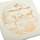 A close-up of a circular gold-foil illustration depicting a bride and groom with a horse-drawn carriage, trees, and a village.