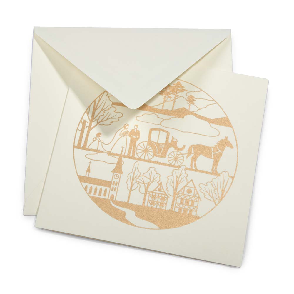 An ivory greeting card with a circular gold illustration showing a wedding scene, partially tucked into a matching envelope.