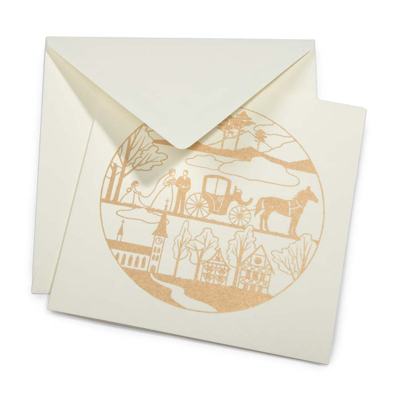 An ivory greeting card with a circular gold illustration showing a wedding scene, partially tucked into a matching envelope.