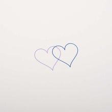 Close up of an ivory greeting card with two small overlapping hearts in blue and lilac set against a clean, minimal background.