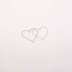 Close up of an ivory greeting card with two small overlapping hearts in pink and gold set against a clean, minimal background.