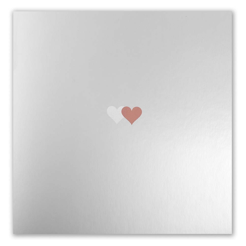 Greeting card with a minimalist design, featuring a smooth mirror-like silver finish and a pair of tiny overlapping hearts in white and bronze placed at the center, presented flat to emphasize the subtle sheen and refined metallic texture.