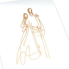 A close-up view of a white card with a minimal gold sketch of two figures, drawn with fluid, continuous lines.