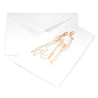 A white greeting card shown partly pulled from a white envelope, featuring a loose gold line drawing of a couple standing close together.