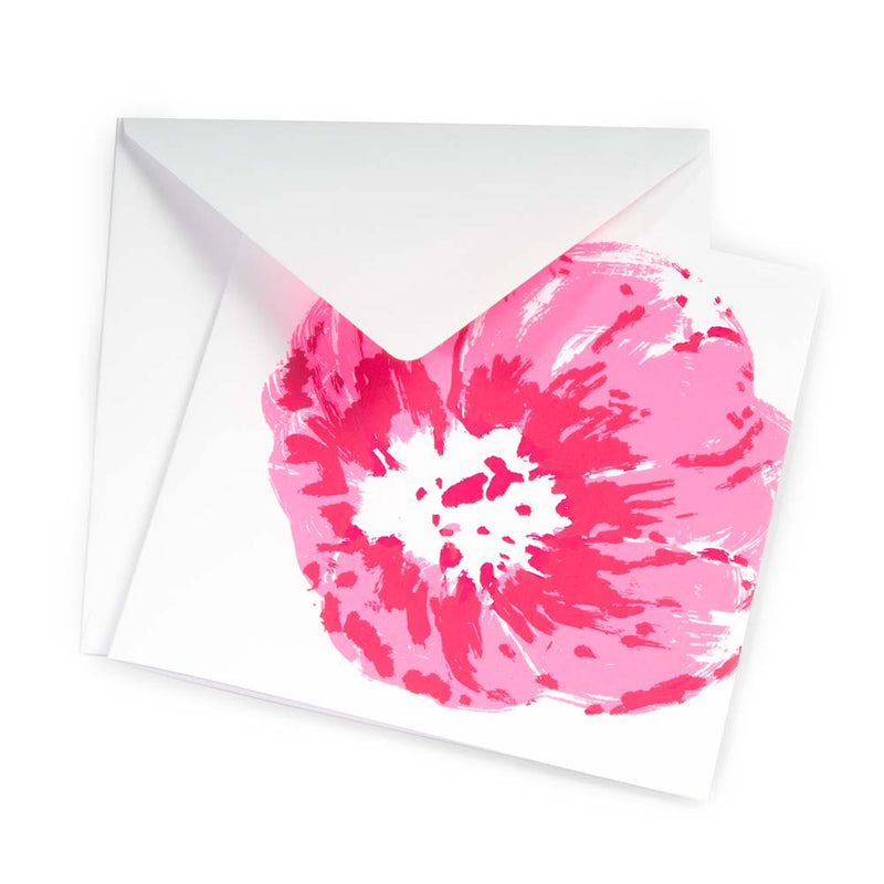 A white greeting card partly pulled from a matching white envelope, shown at a slight angle, featuring a large expressive pink flower painted with loose, energetic brushstrokes.