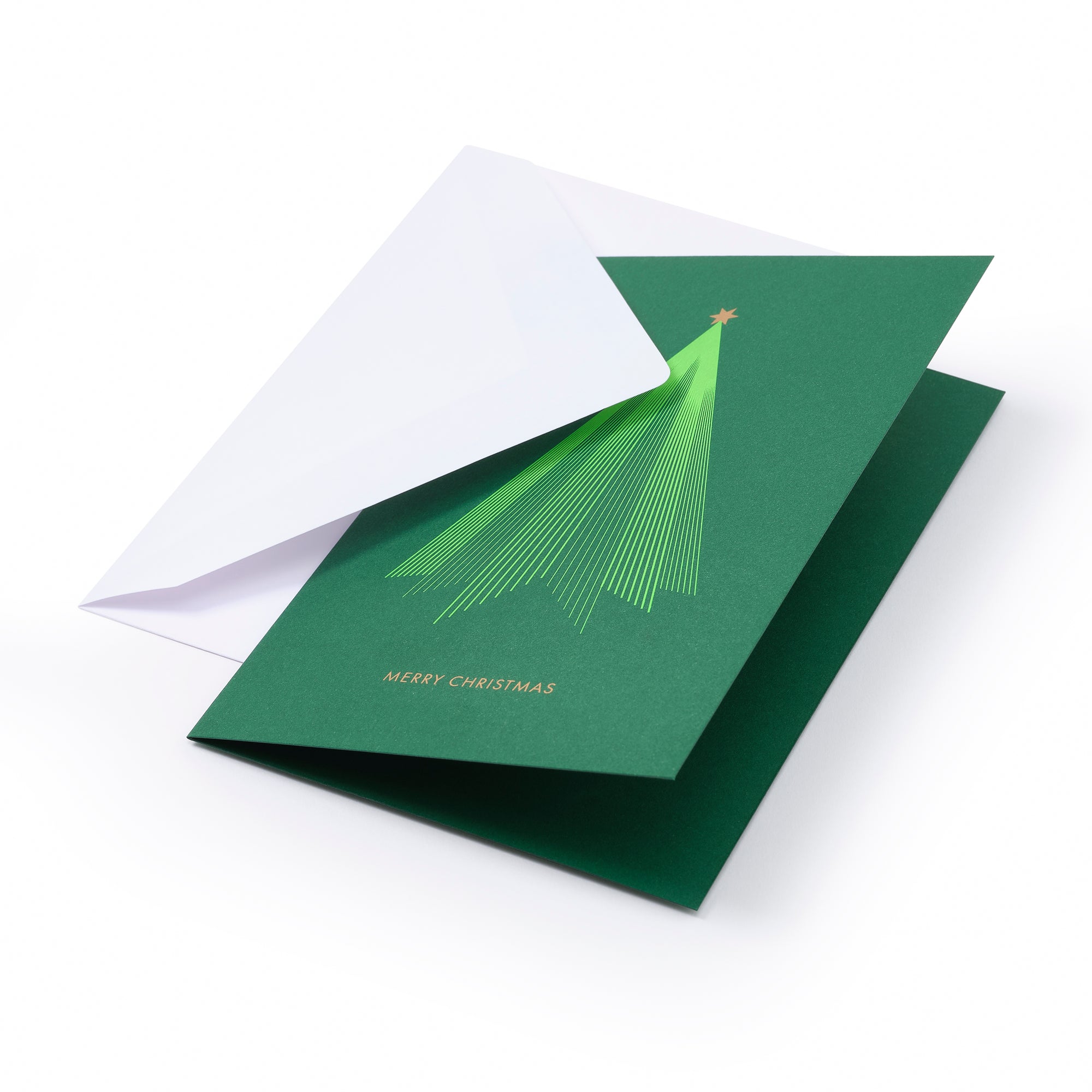 A green Christmas card with a stylized tree design and the words "Merry Christmas," partially inserted into a white envelope on a white background.