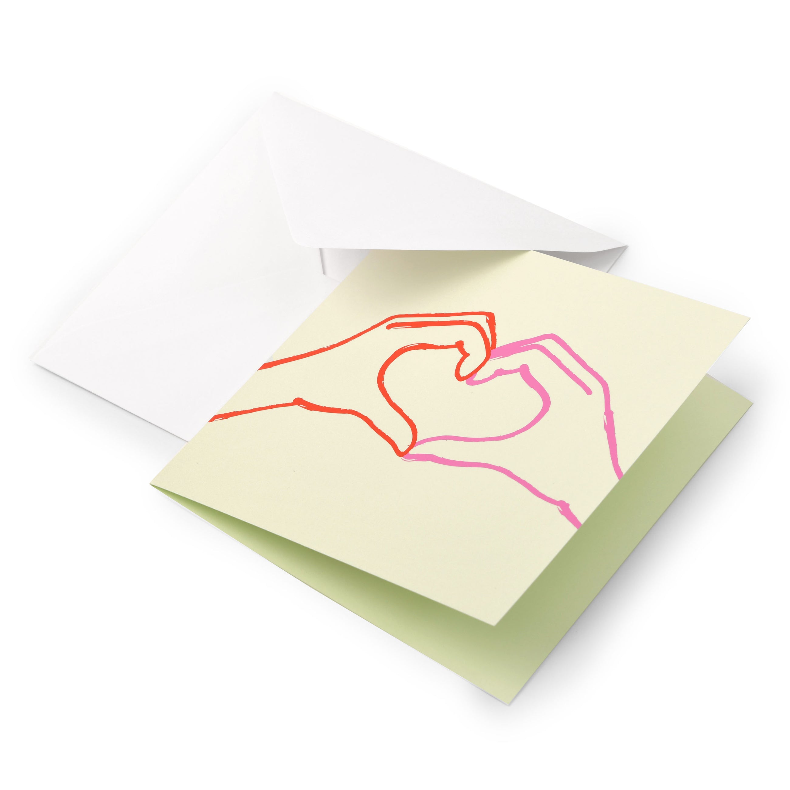 Greeting card with a minimalist line illustration of two hands forming a heart, drawn in red and pink on a soft light-green background, shown partially inside a white envelope.