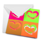 Wrapping paper–inspired greeting card featuring four vivid brush-painted hearts in a neon pop-art grid, displayed emerging from a white envelope with strong color contrasts.