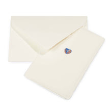 Greeting card with a minimalist design, featuring a tiny blue-and-copper heart on cream handmade paper, shown alongside a matching deckle-edged envelope.