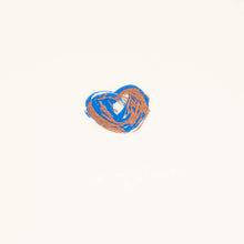 Greeting card with a minimalist design, featuring a small blue-and-copper painted heart centered on cream handmade paper, shown closed against a clean white background.