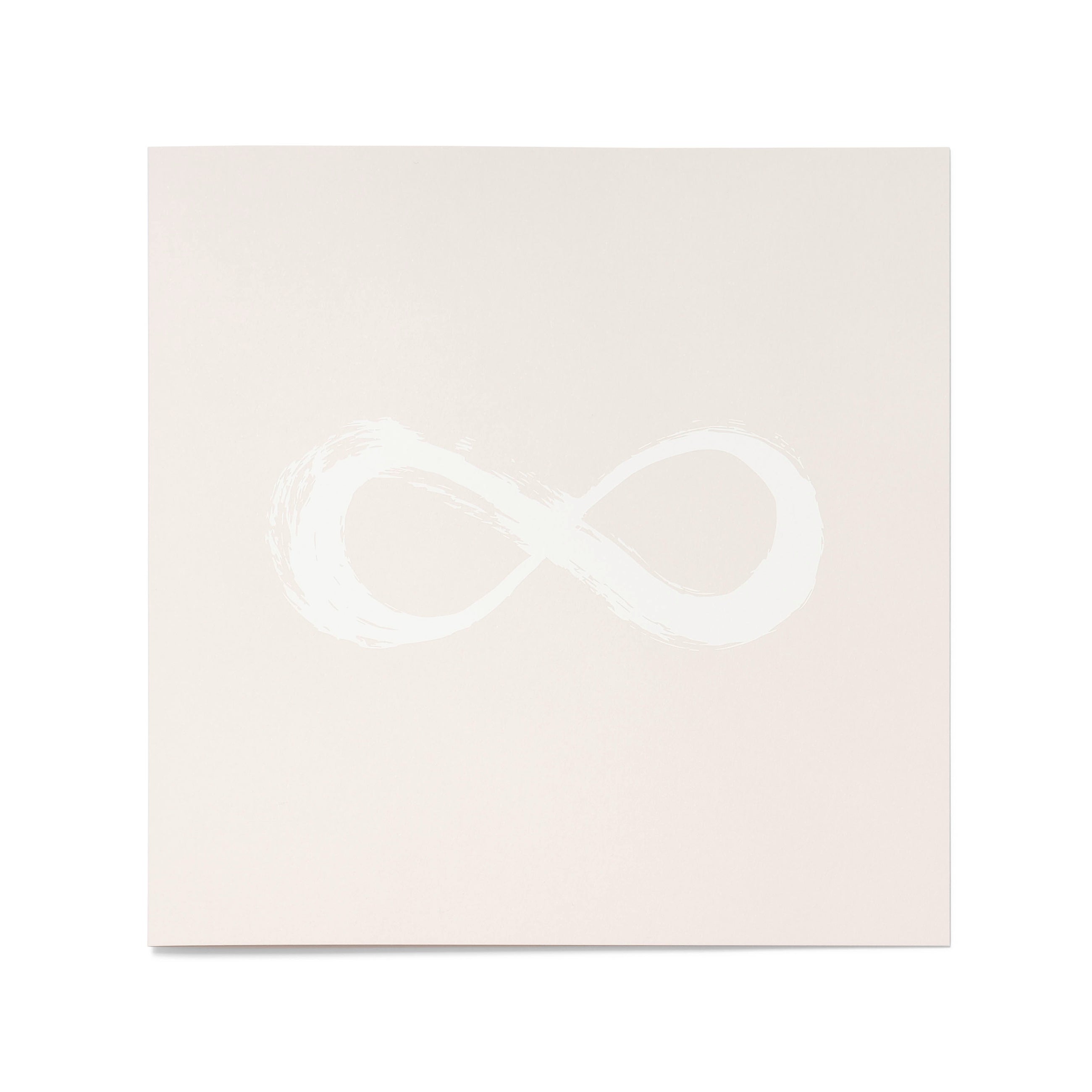 A flat view of a pale sand-colored greeting card with a white infinity symbol centered on the surface.