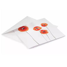 A greeting card partially tucked into a white envelope, featuring a delicate illustration of red and orange poppy flowers with loose, painterly shapes and fine linear stems.