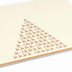 A close-up of an elegant cream Christmas card decorated with a triangular pattern of small gold reindeer forming the shape of a Christmas tree.