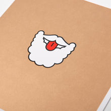 A close-up of a humorous Christmas card with a cartoon illustration of Santa’s white beard and mustache with his red tongue sticking out.