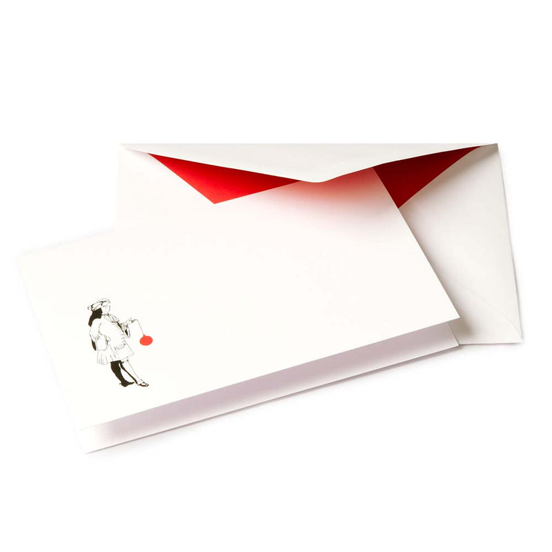 White Christmas card with a black illustration of a noble figure holding a large red Christmas ornament, paired with a red-lined envelope.
