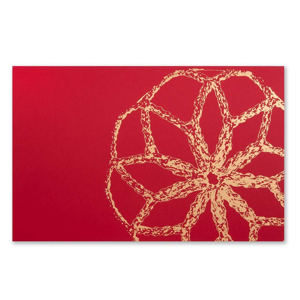 A Christmas card with a large golden bauble design on a bright red background.