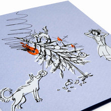 A close-up of a humorous Christmas card on a light blue background showing a toppled Christmas tree, a playful dog, and a shocked woman reacting to the chaos.