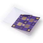 Christmas card decorated with a purple and gold checkerboard pattern showing Christmas motifs such as hearts, stars, ornaments, and a rocking horse, paired with a plain white envelope.