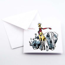 White Christmas card with an illustrated giraffe wearing a red scarf, walking alongside an elephant and a rhinoceros, with the text “Coming home for Christmas," paired with a plain white enevelope.