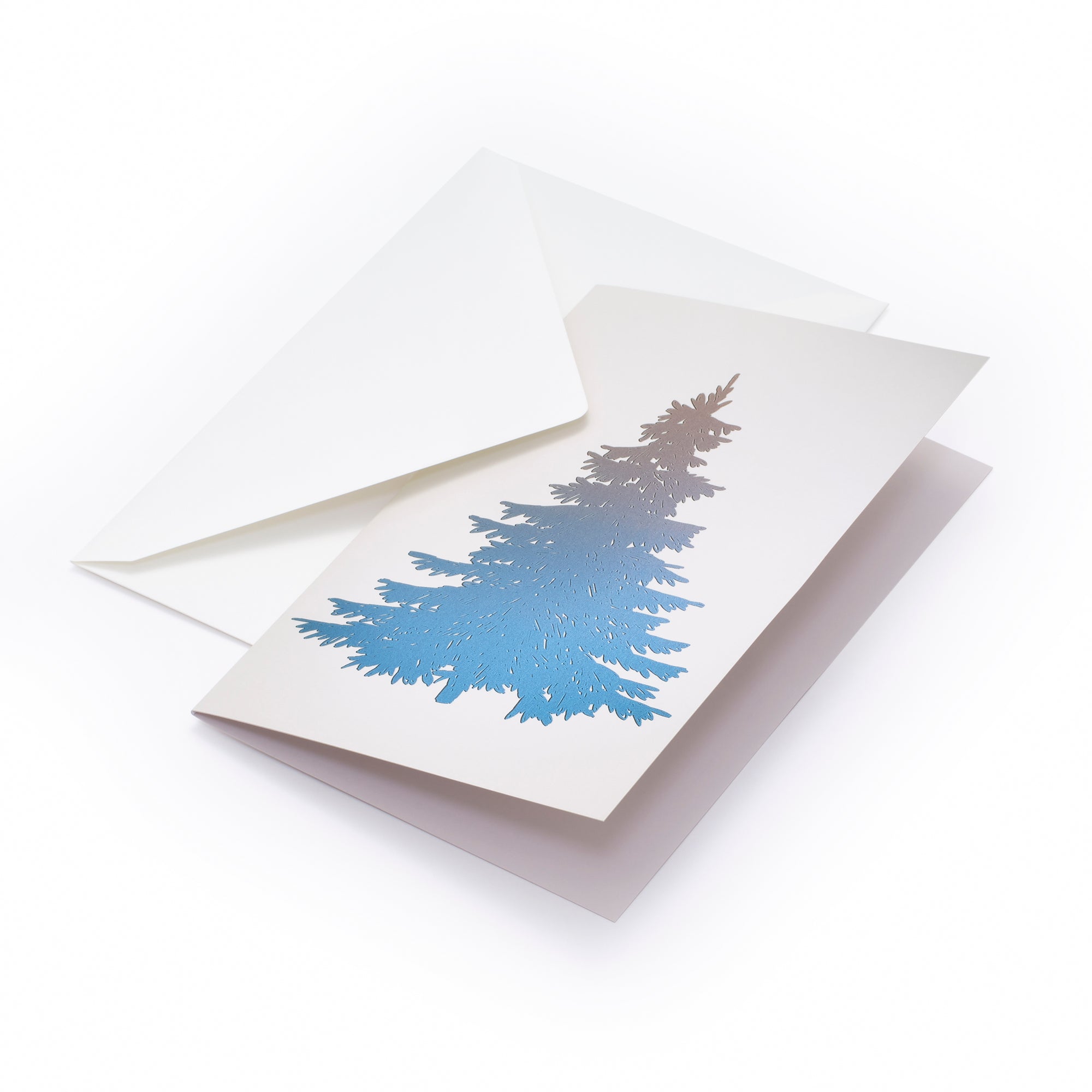 White Christmas card featuring a large stylized Christmas tree in shimmering blue foil, accompanied by a plain white envelope.