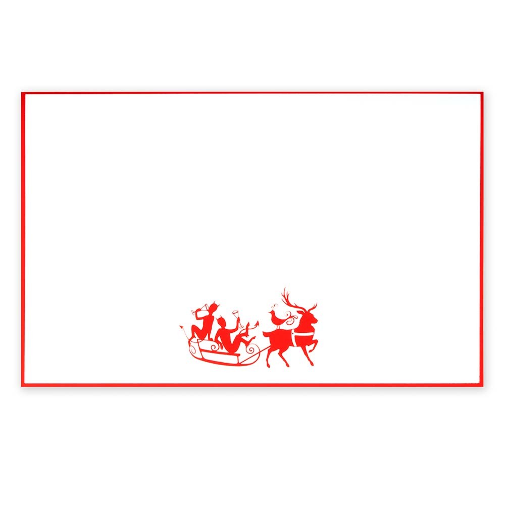 White Christmas card with red border, featuring a playful illustration of two reindeer pulling a sleigh with characters raising glasses.