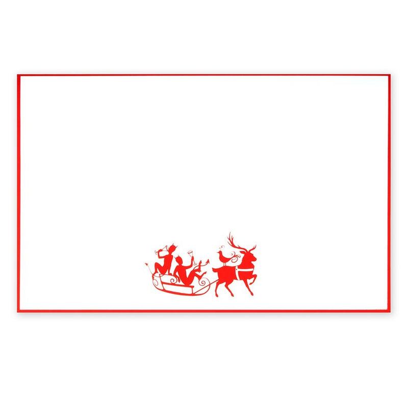 White Christmas card with red border, featuring a playful illustration of two reindeer pulling a sleigh with characters raising glasses.