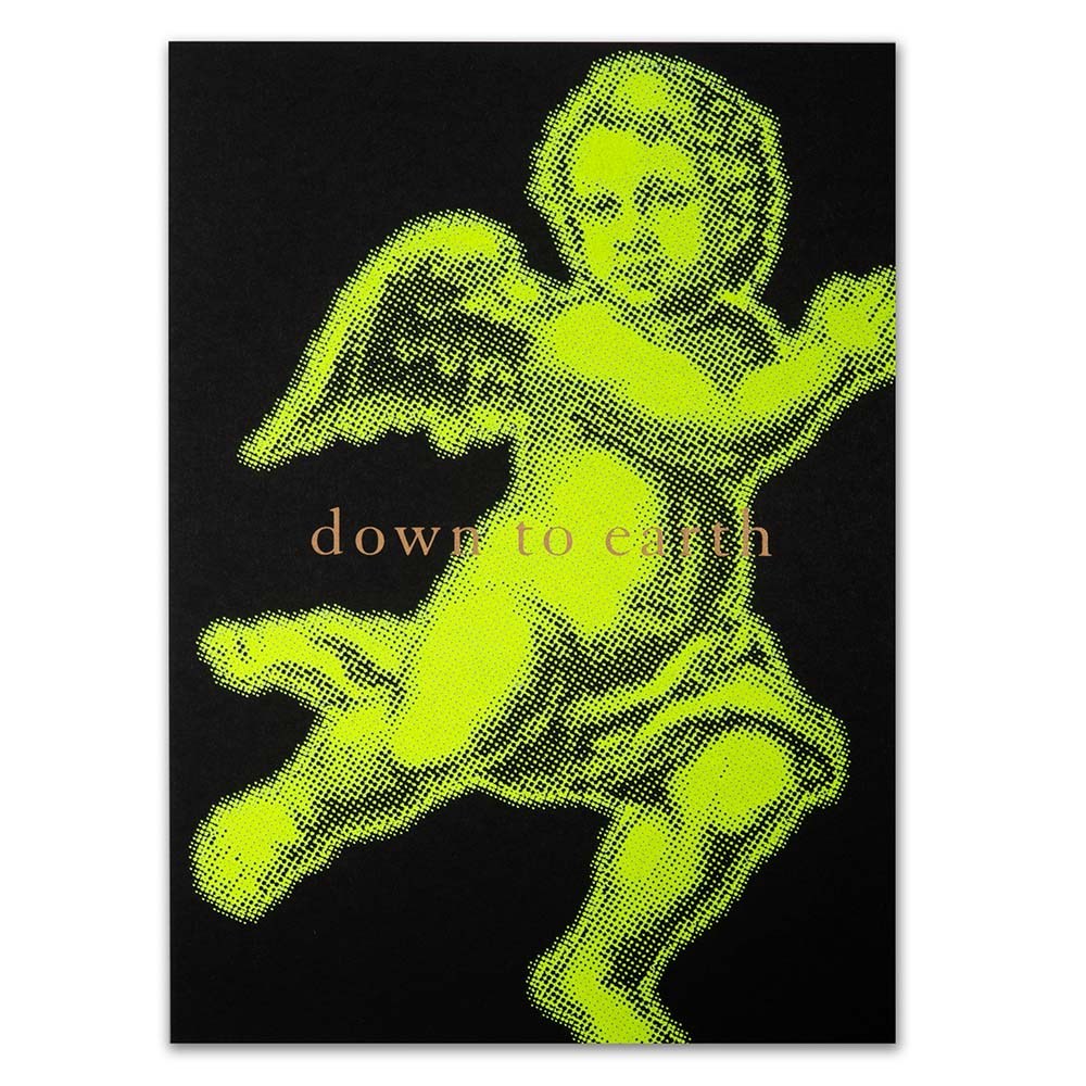 Christmas card with a bold neon yellow angel illustration on a black background, accompanied by the text 'down to earth'.