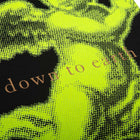A close-up of a Christmas card with a bold neon yellow angel illustration on a black background, accompanied by the text 'down to earth'.