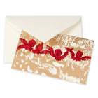 A Christmas card with red silhouettes of flying angels on a rustic golden textured background, paired with a cream envelope.