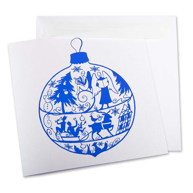 White Christmas card featuring a large blue ornament illustration with angels, reindeer, trees, and holiday motifs, accompanied by a matching envelope.