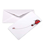 Minimalist Christmas card with a white background featuring an illustration of a red hot air balloon pulling Santa Claus hanging from a rope. Comes with a matching white envelope.