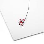 A close-up of a minimalist Christmas card with a white background featuring an illustration of Santa Claus being pulled by a rope.