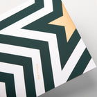 The back of a Christmas card featuring a bold zigzag pattern in dark green and white with a golden star forming a stylized Christmas tree, with the text "Bethge".