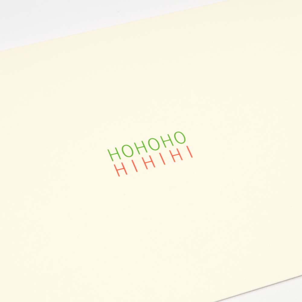 A close-up of a minimalist cream-colored Christmas card with the words 'HOHOHO' in green and 'HIHIHI' in red printed in the center.